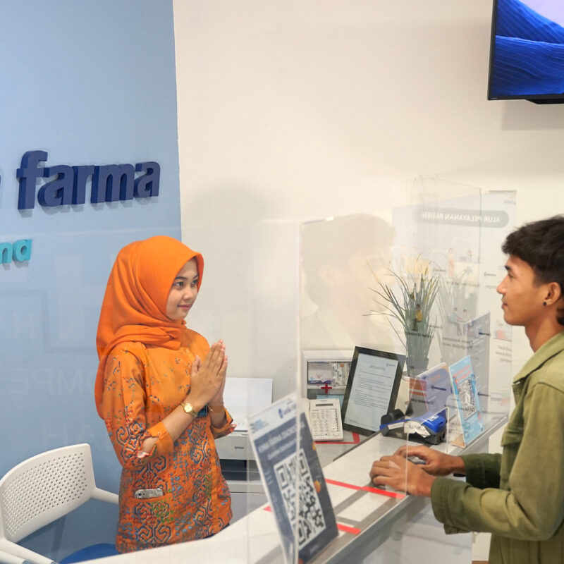 Two people talk at the front desk of a lab