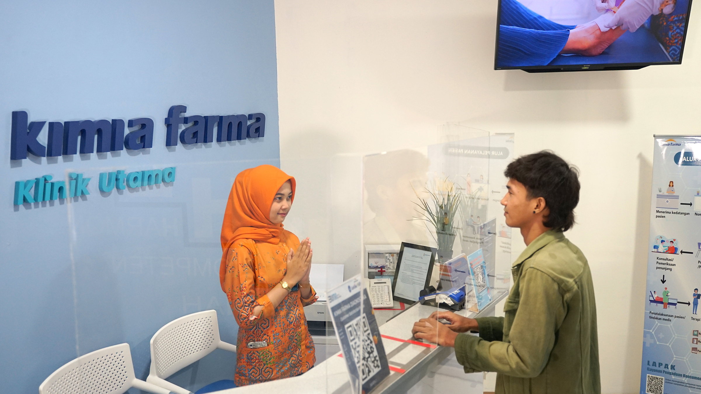 Two people talk at the front desk of a lab