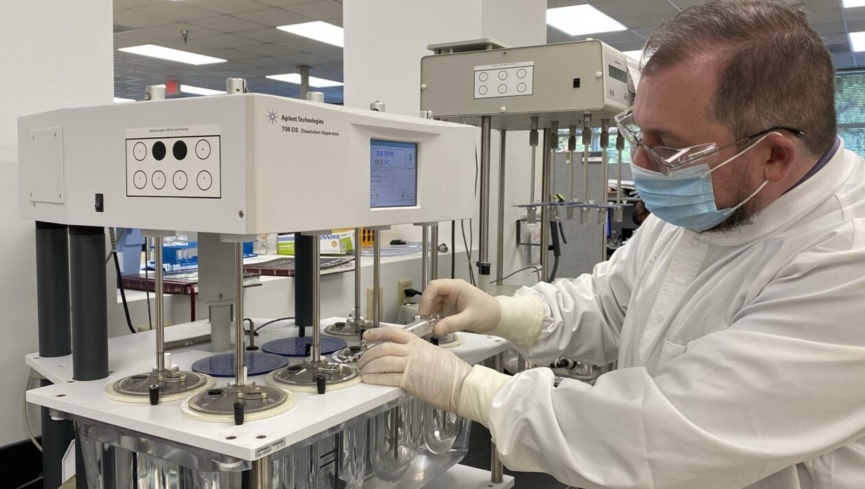 A lab technician tests a sample in a machine.