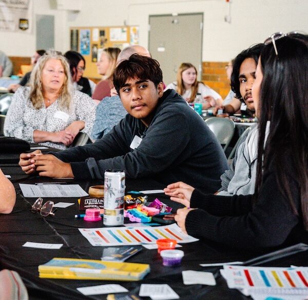 A group of people sitting at a table with activity material.