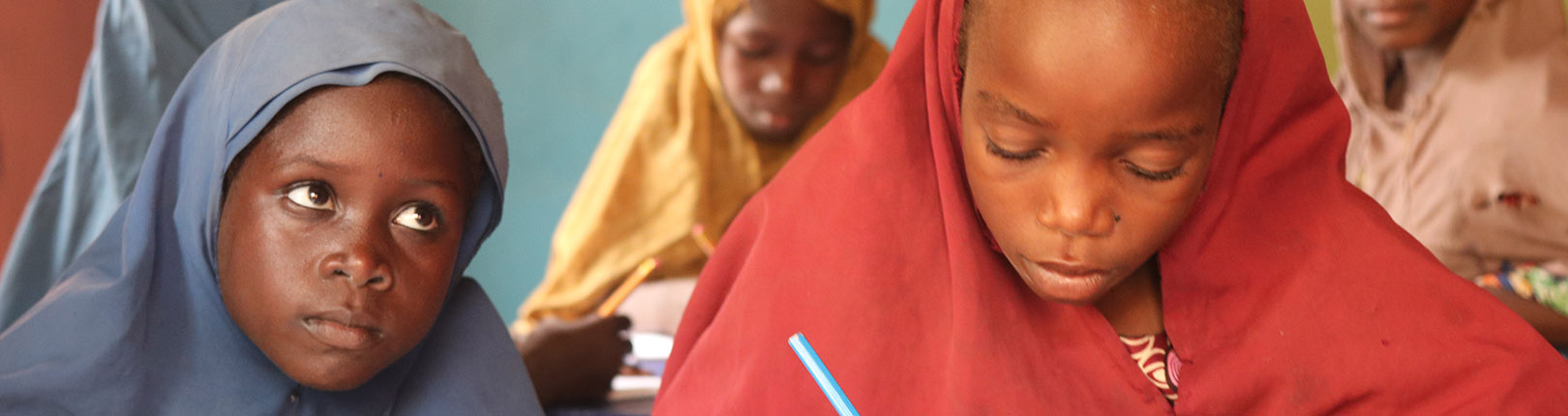 Two young girls listen to their teacher