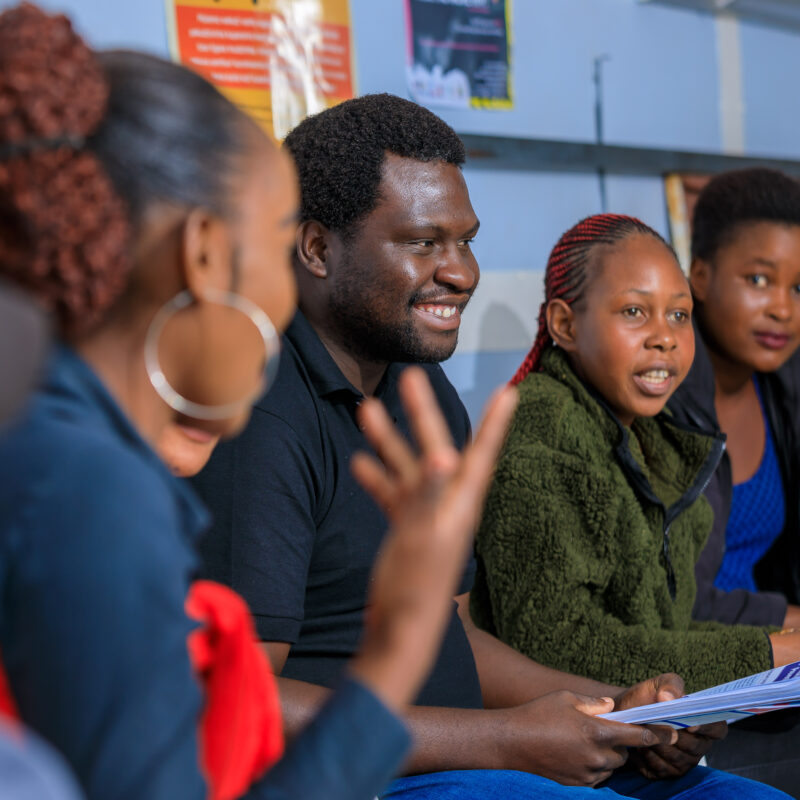 smiling group discussion in circle in Zimbabwe