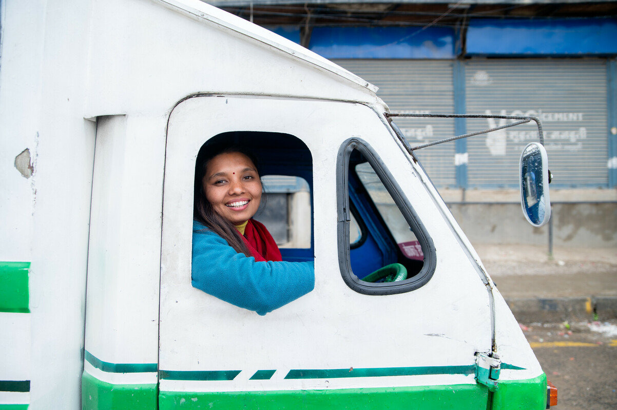 woman smiling driving electric vehicle