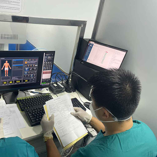 A man in medical scrubs sitting in front a of a computer