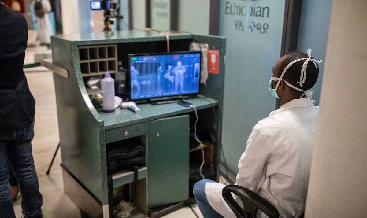 A doctor wearing a mask examines x-rays