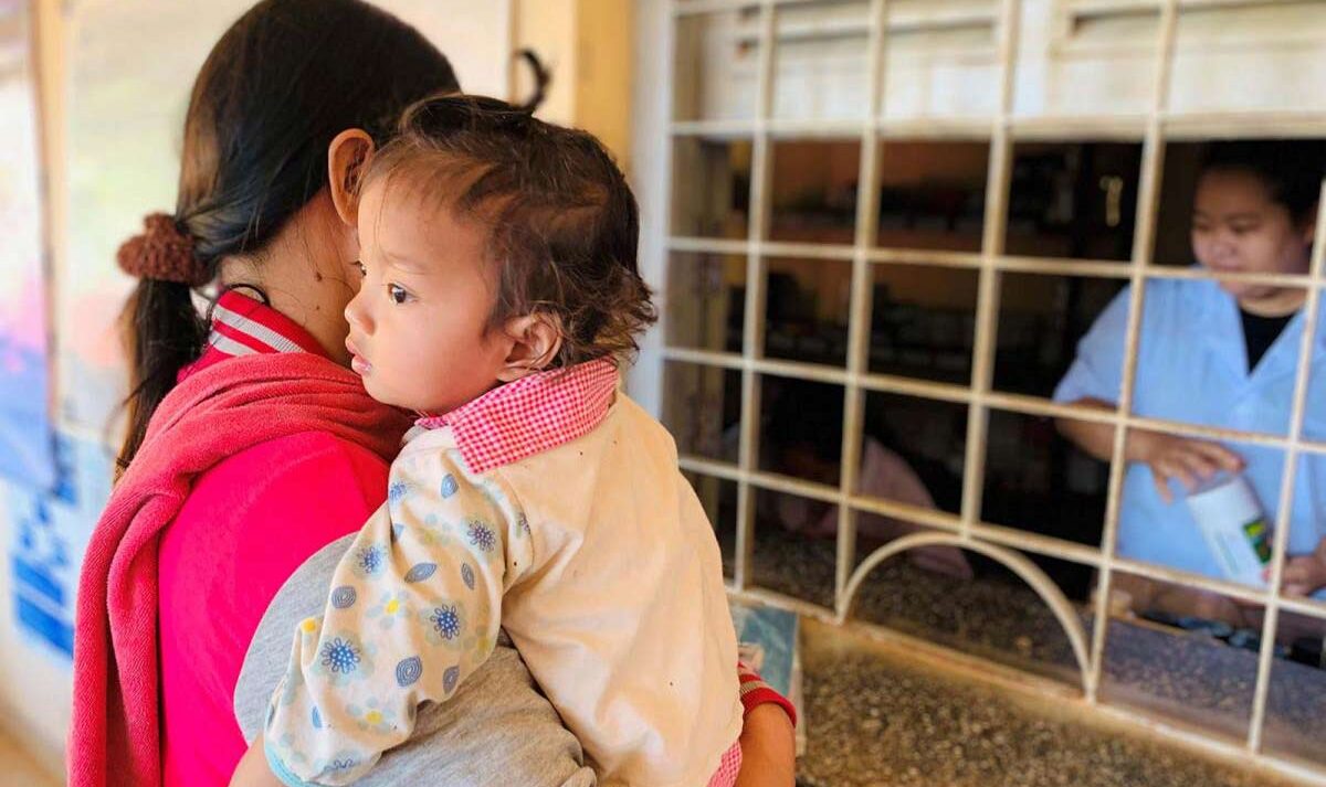 A mother holding her toddler at a medical office