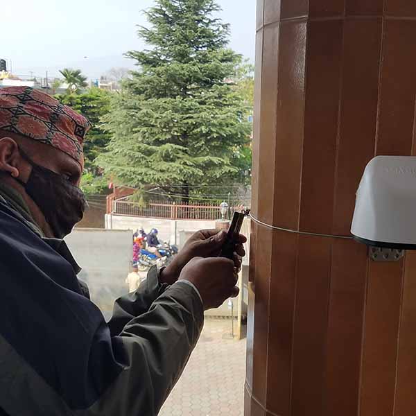 man placing sensor on home to monitor air quality.