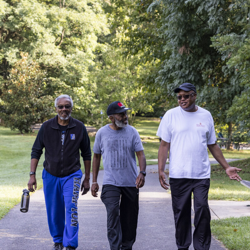 Three men walking in a park