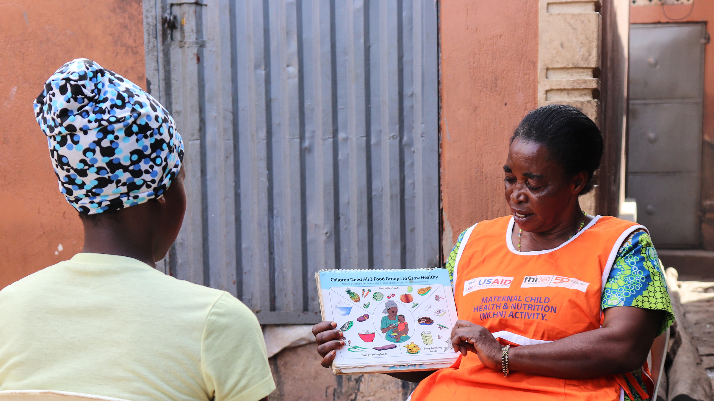 Community health worker sharing nutrition graphic with another woman