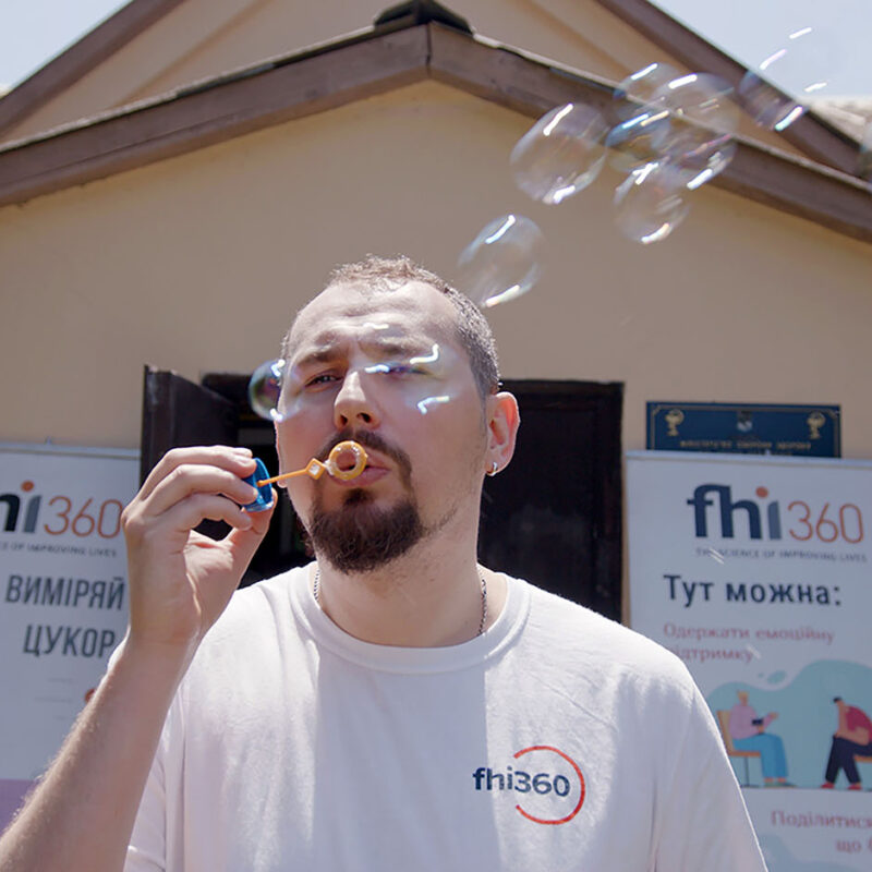 A man blows bubbles with a bubble wand