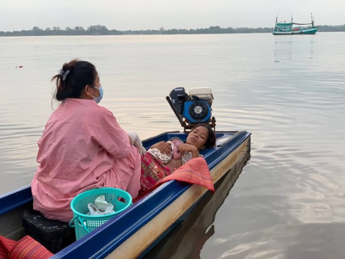 At right, Saloeng rests with her baby in boat.