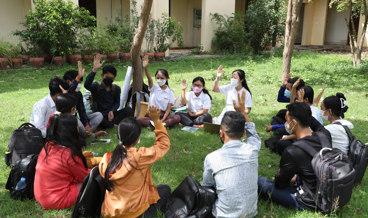 group discussion of young people in a sitting outside in a circle