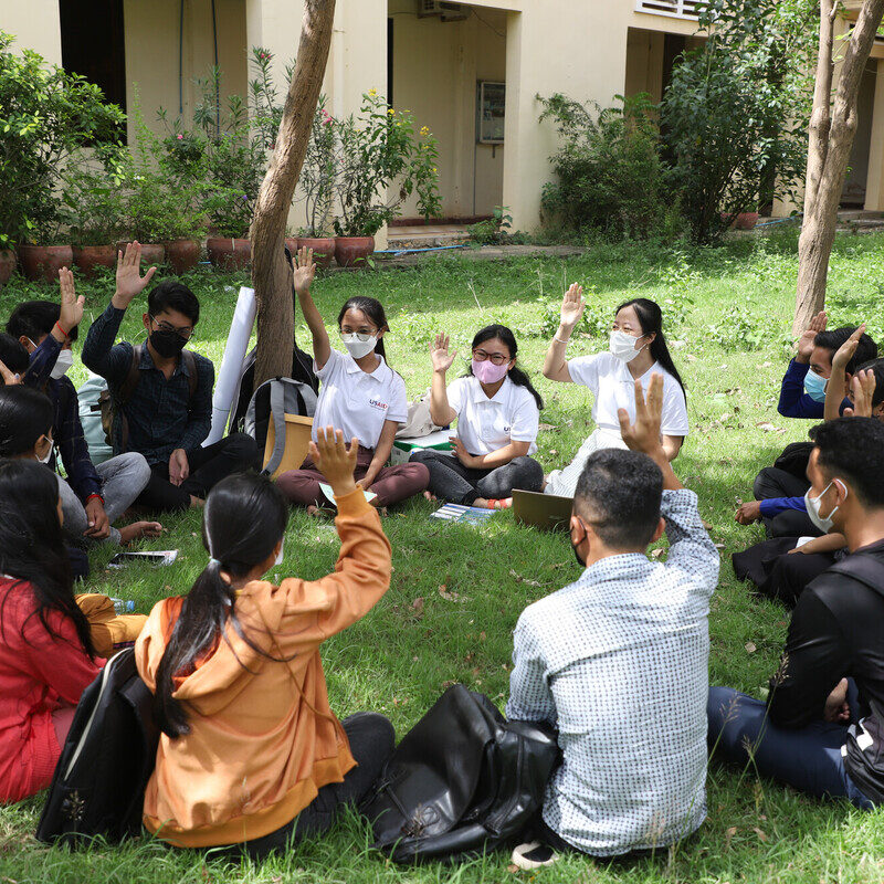 group discussion of young people in a sitting outside in a circle