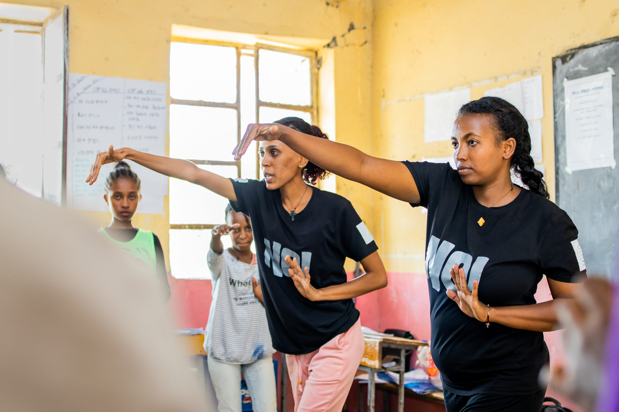 Instructors demonstrating movements to class of young girls in Ethiopia.