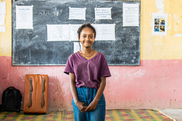 Portrait of young female student smiling in classroom.