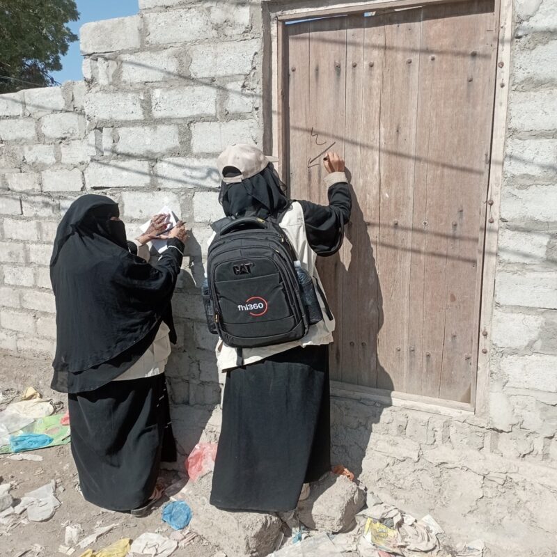 FHI 360 staff going door to door looking for children to treat with severe acute malnutrition.