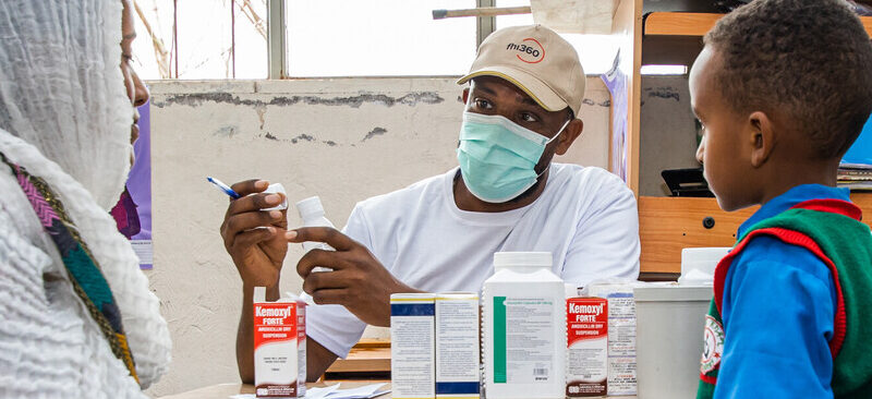 Mom and son receive medicine from a health worker