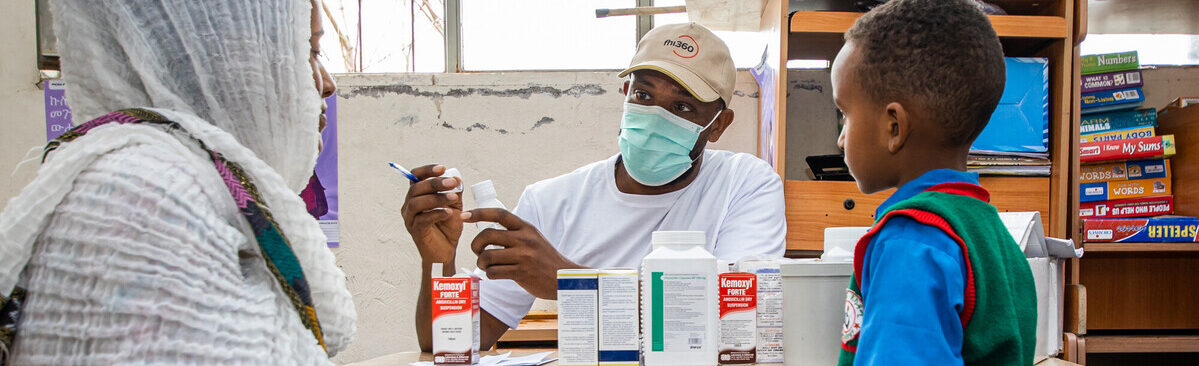 Mom and son receive medicine from a health worker