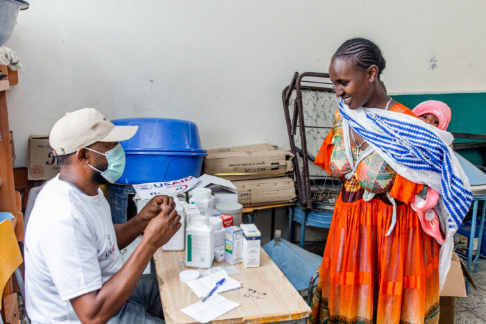 Pharmacist gives patient medication instructions at a temporary clinic