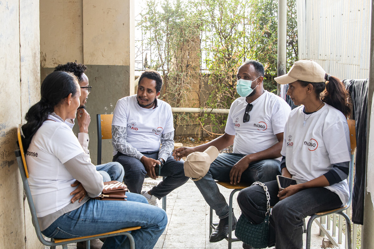 Mobile medical team workers sit in circle taking a break