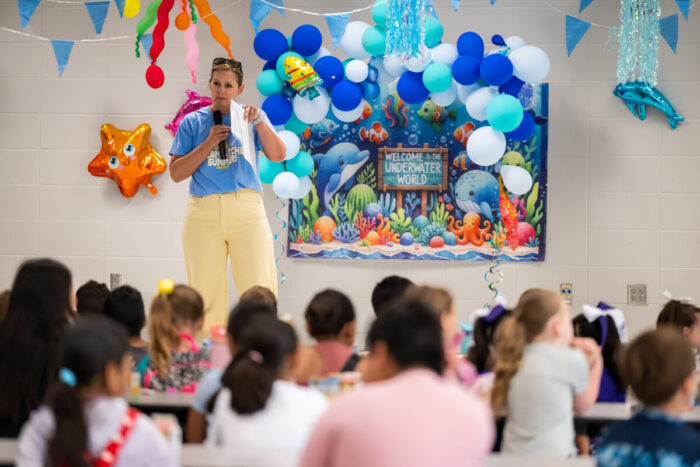 Teacher presents on stage in front of students