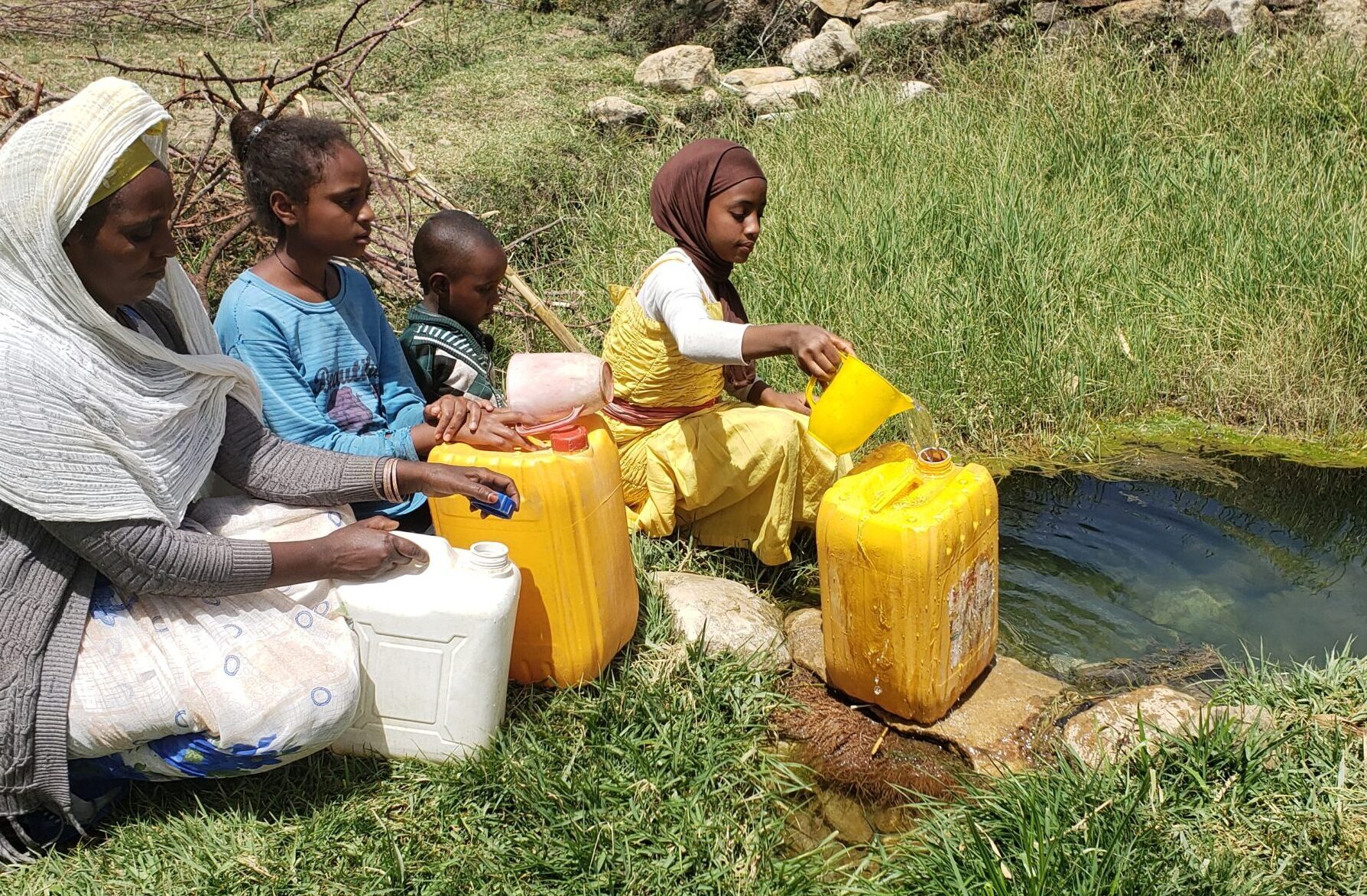 11 year old Eman and her family gather water from a river