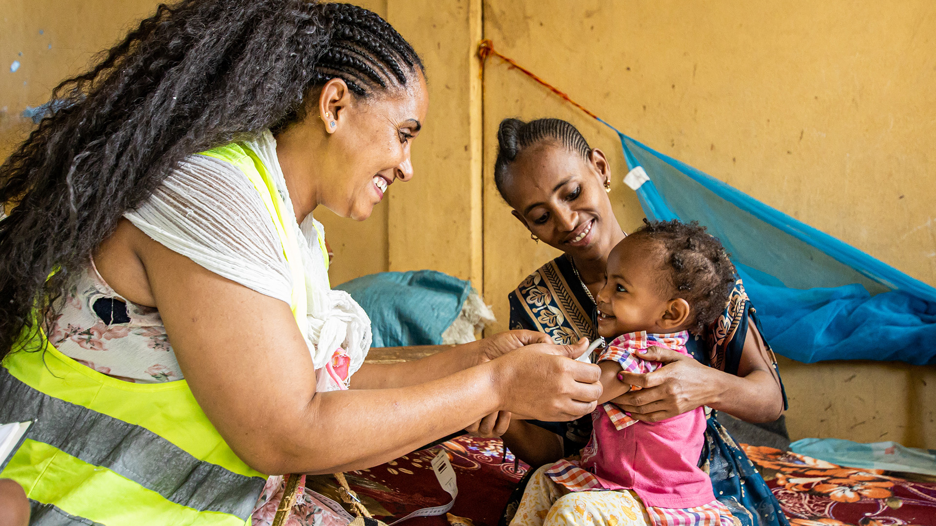 A health worker listens to a boy’s breathing with a stethoscope.