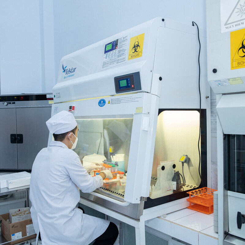 A man in a laboratory sits in front of a testing machine.