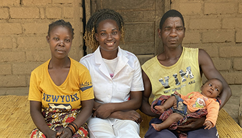 A nurse sits between a woman and a man holding a baby.