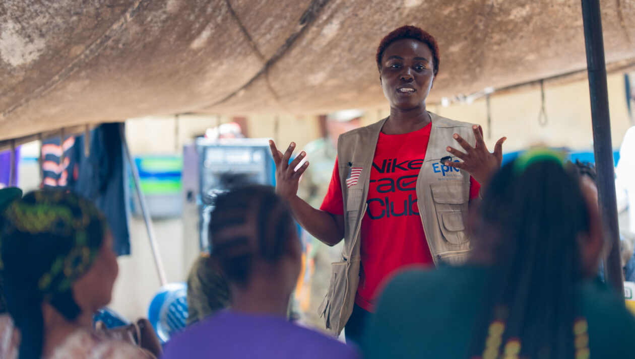 A woman speaks at an ebola training in front of a group of people.