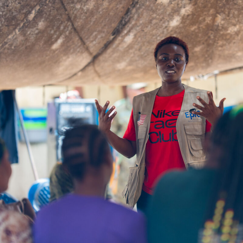 A woman speaks at an ebola training in front of a group of people.