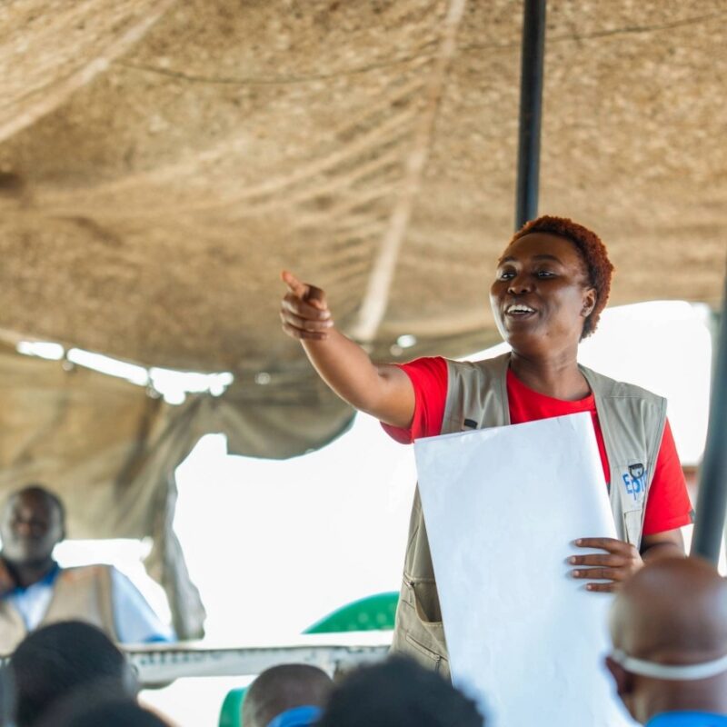 A woman addresses a sitting audience.