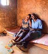Photo caption: A farm couple relaxes on a mattress in their hut in the war-weary Gulu District of Northern Uganda.